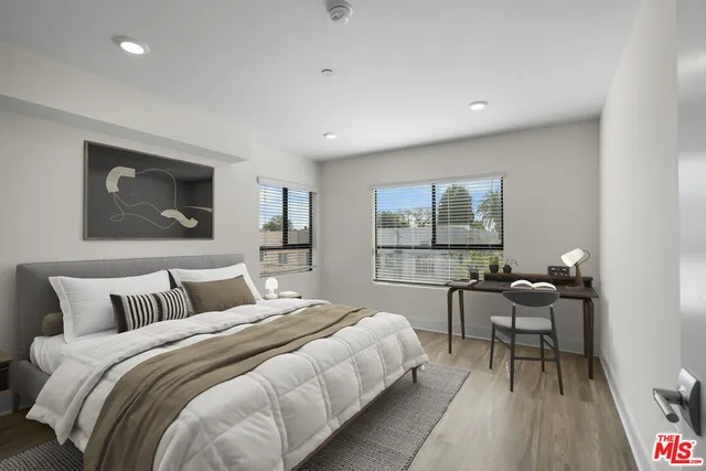 a bedroom with a bed and large windows