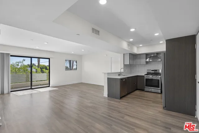 a large kitchen with a large counter top and stainless steel appliances