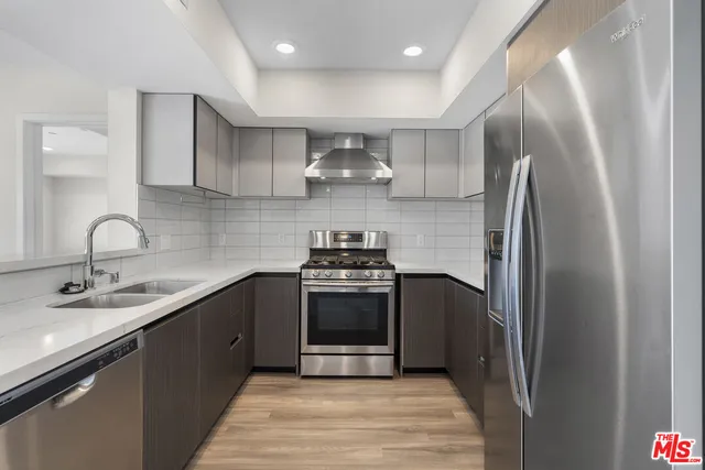 a kitchen with stainless steel appliances granite countertop a sink stove and refrigerator