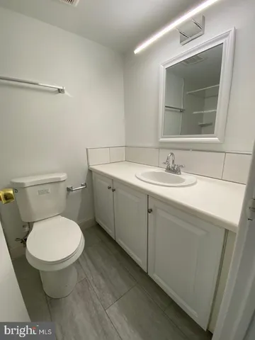a white bath tub sitting next to a white toilet and vanity