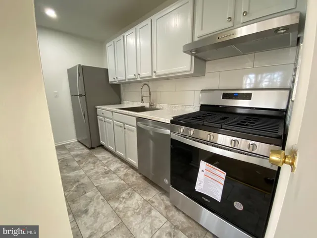 a kitchen with stainless steel appliances granite countertop a stove a refrigerator and a microwave