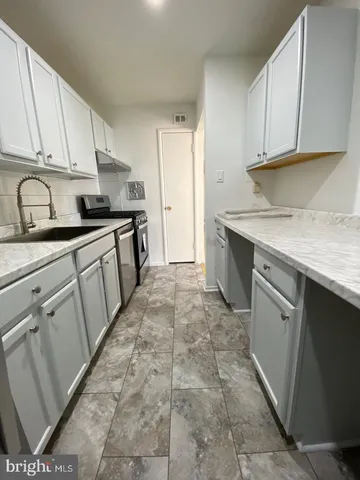 a kitchen with a sink stove and cabinets