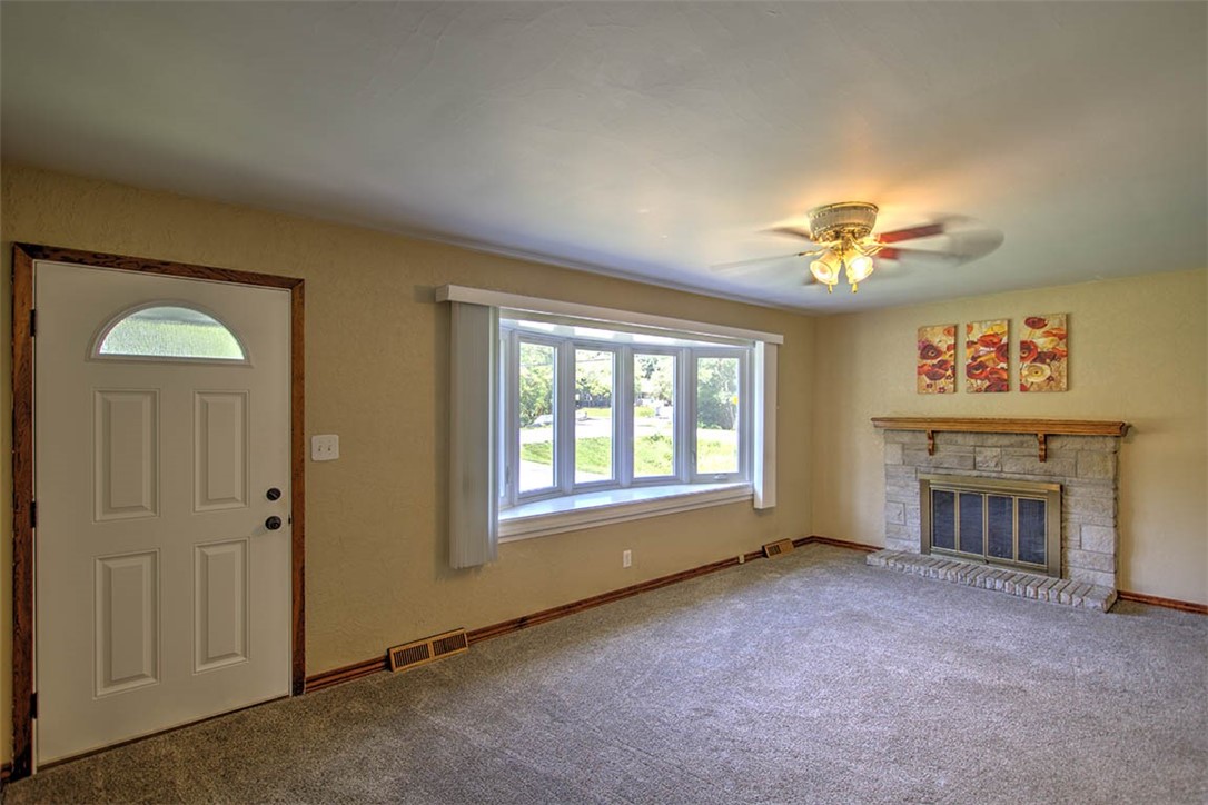 3454 North Christine Drive Decatur, IL 62526 - Photo 2 of 23 an empty room with windows fireplace and fans