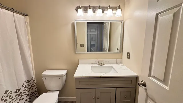 a bathroom with a toilet a sink and a mirror