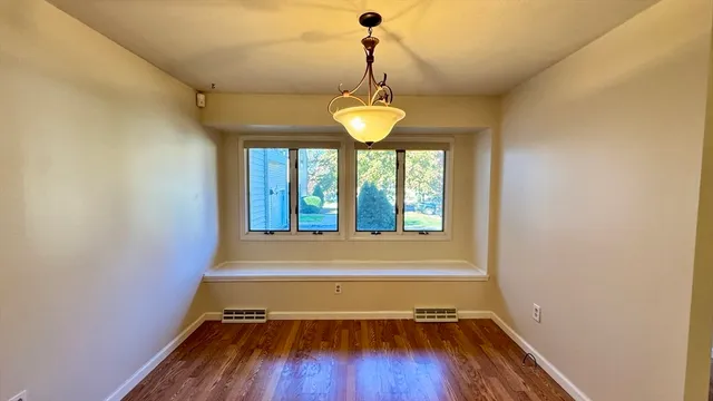 a view of a room with wooden floor and a window