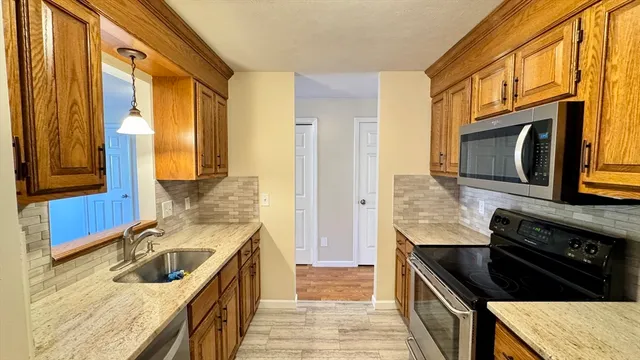 a kitchen with granite countertop a stove and a sink