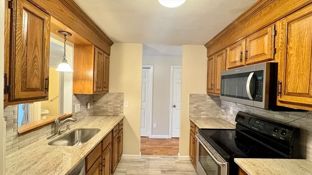 a kitchen with granite countertop a sink and a stove top oven
