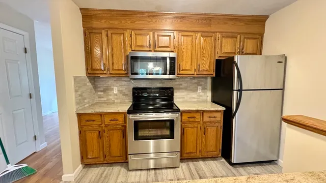 a kitchen with a stove refrigerator and microwave