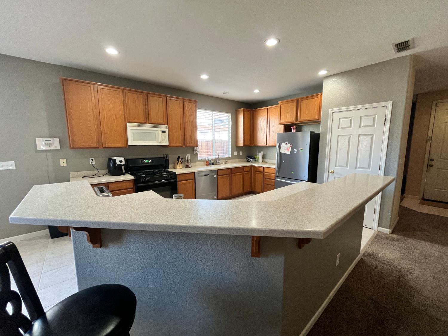 1117 Marsh Wren Court Patterson, CA 95363 - Photo 11 of 41 a kitchen with stainless steel appliances a stove a sink a microwave a refrigerator and cabinets
