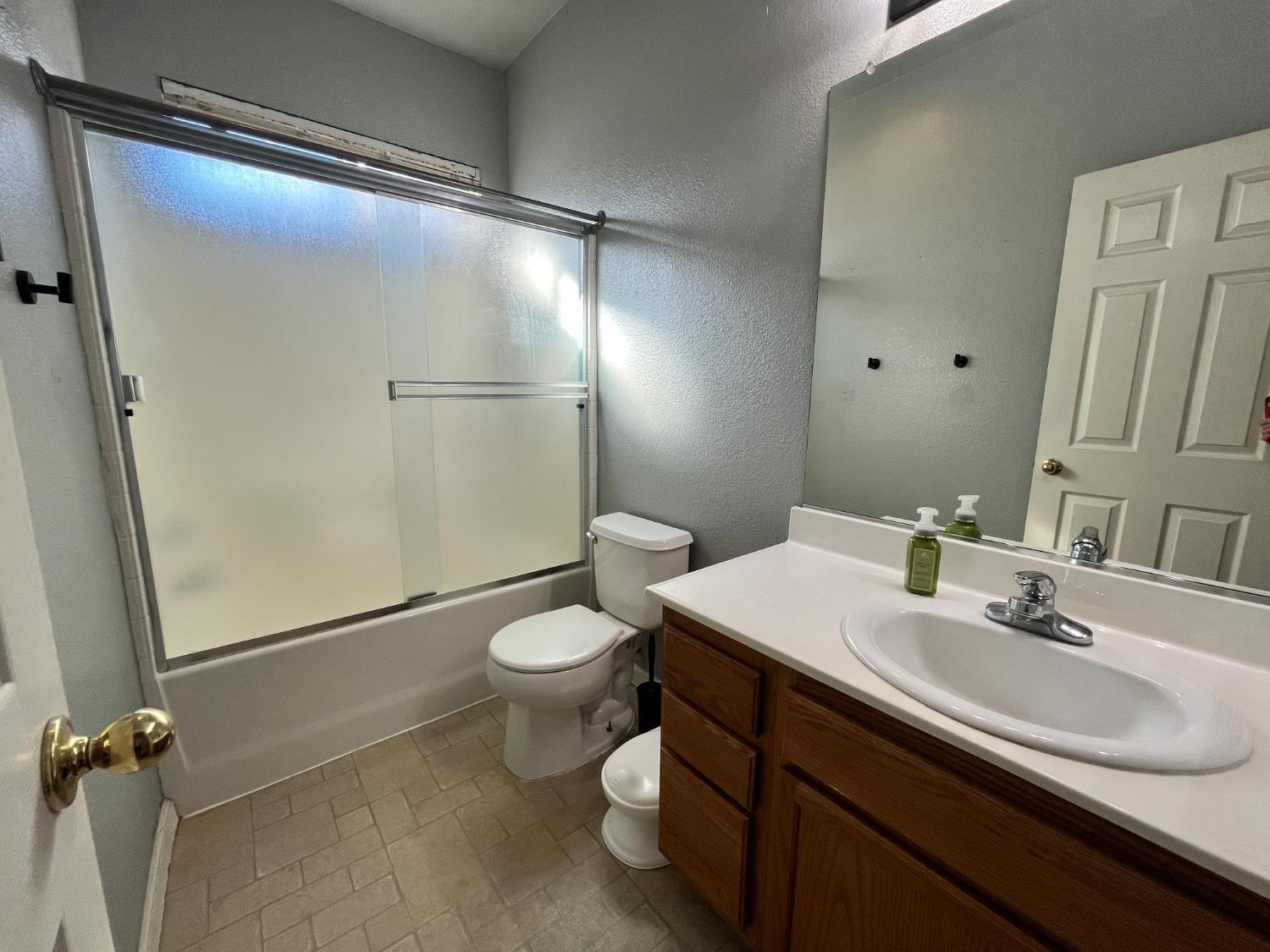 1117 Marsh Wren Court Patterson, CA 95363 - Photo 27 of 41 a bathroom with a sink mirror vanity and toilet