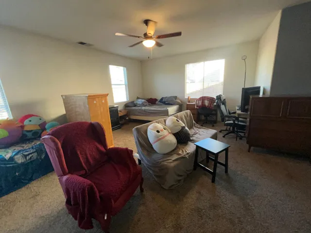 a living room with furniture a ceiling fan and a window