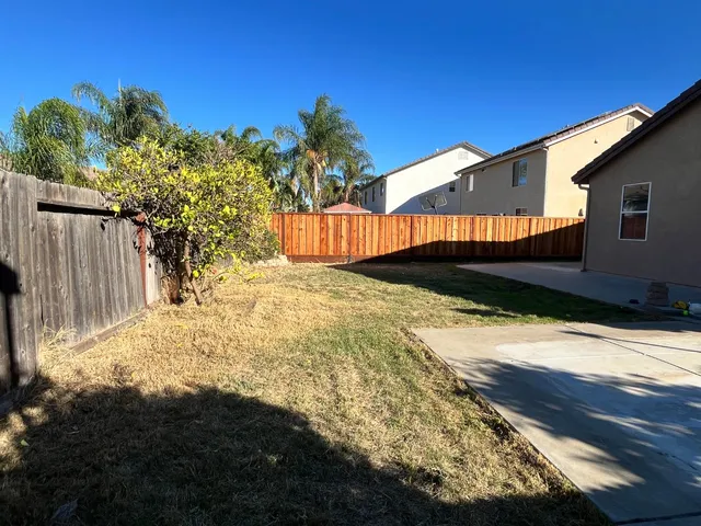 a view of a house with backyard and sitting area
