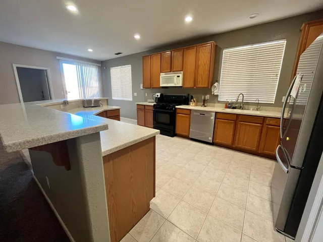 a kitchen with stainless steel appliances granite countertop sink stove top oven and cabinets
