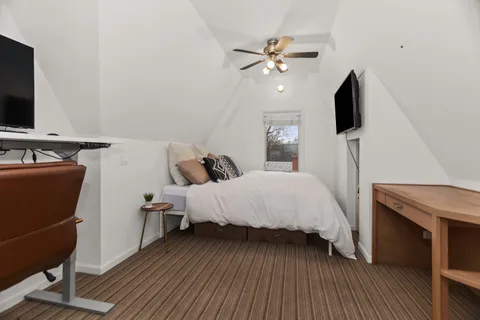 a bed room with a bed tv and a mirror