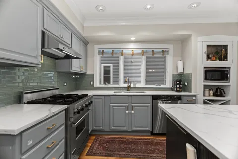 a kitchen with a stove sink and cabinets