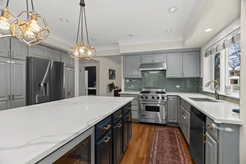 a kitchen with kitchen island granite countertop a sink stove and refrigerator