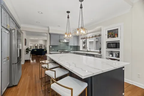 a kitchen with a table chairs and a chandelier