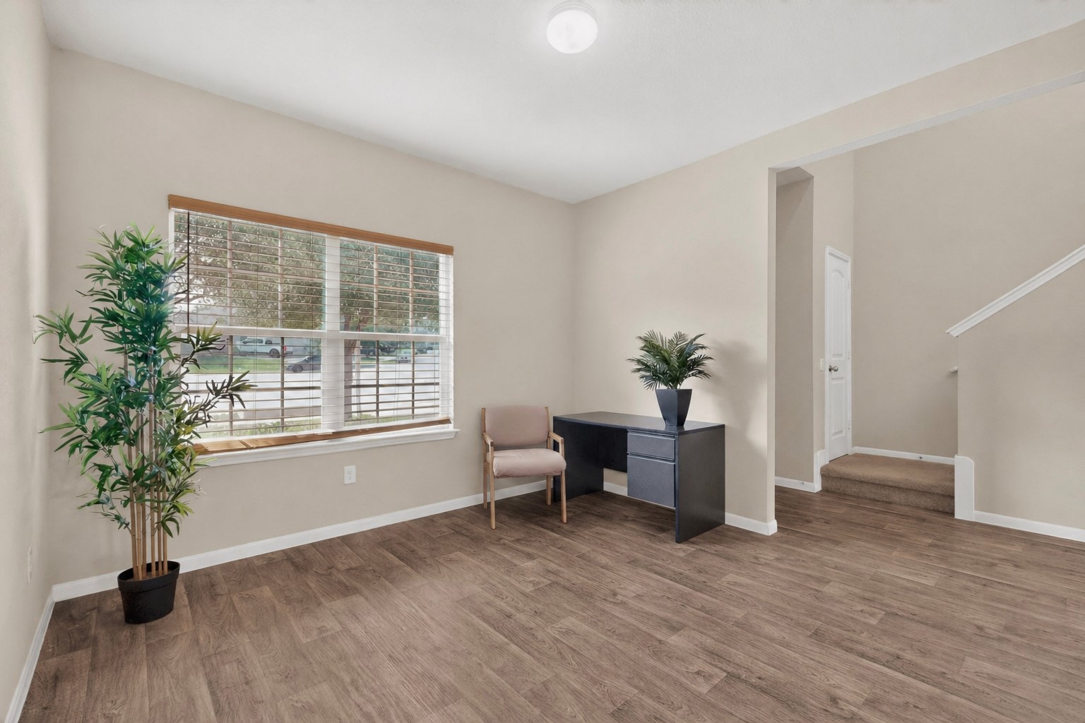 5905 Diamondleaf Bend Austin, TX 78724 - Photo 6 of 38 Open concept living space featuring wood-finish flooring, a large window with blinds, and neutral wall paint