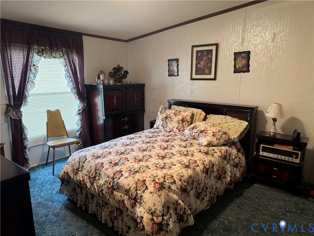 832 Evans Creek Road Brodnax, VA 23920 - Photo 5 of 13 a bed sitting in a bedroom next to a window with chair and couch