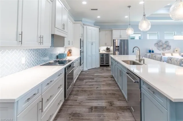 a large kitchen with stainless steel appliances granite countertop a lot of counter space and wooden floors