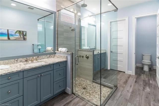 a bathroom with a granite countertop sink mirror and shower