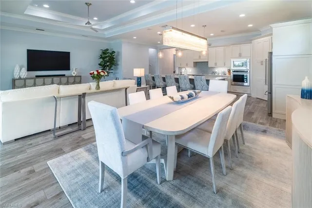 a dining room with furniture a large window and a flat screen tv