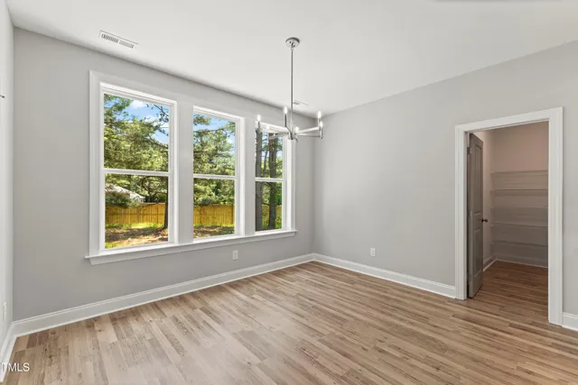 a kitchen with white cabinets and a stove with wooden floor