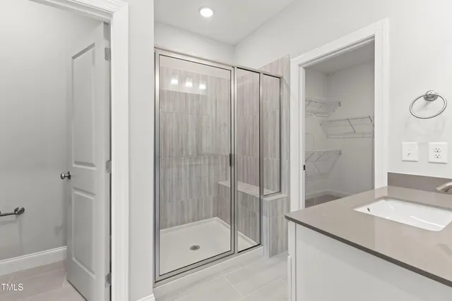 a bathroom with a sink double vanity granite tub shower and a mirror
