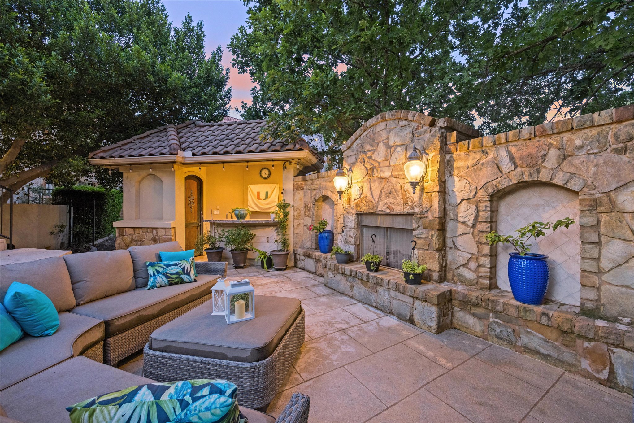 11805 Ranchview Court Austin, TX 78732 - Photo 31 of 36 Spacious hardscaped patio featuring a stone-clad outdoor kitchen, built-in stone fireplace, and a tiled roof structure