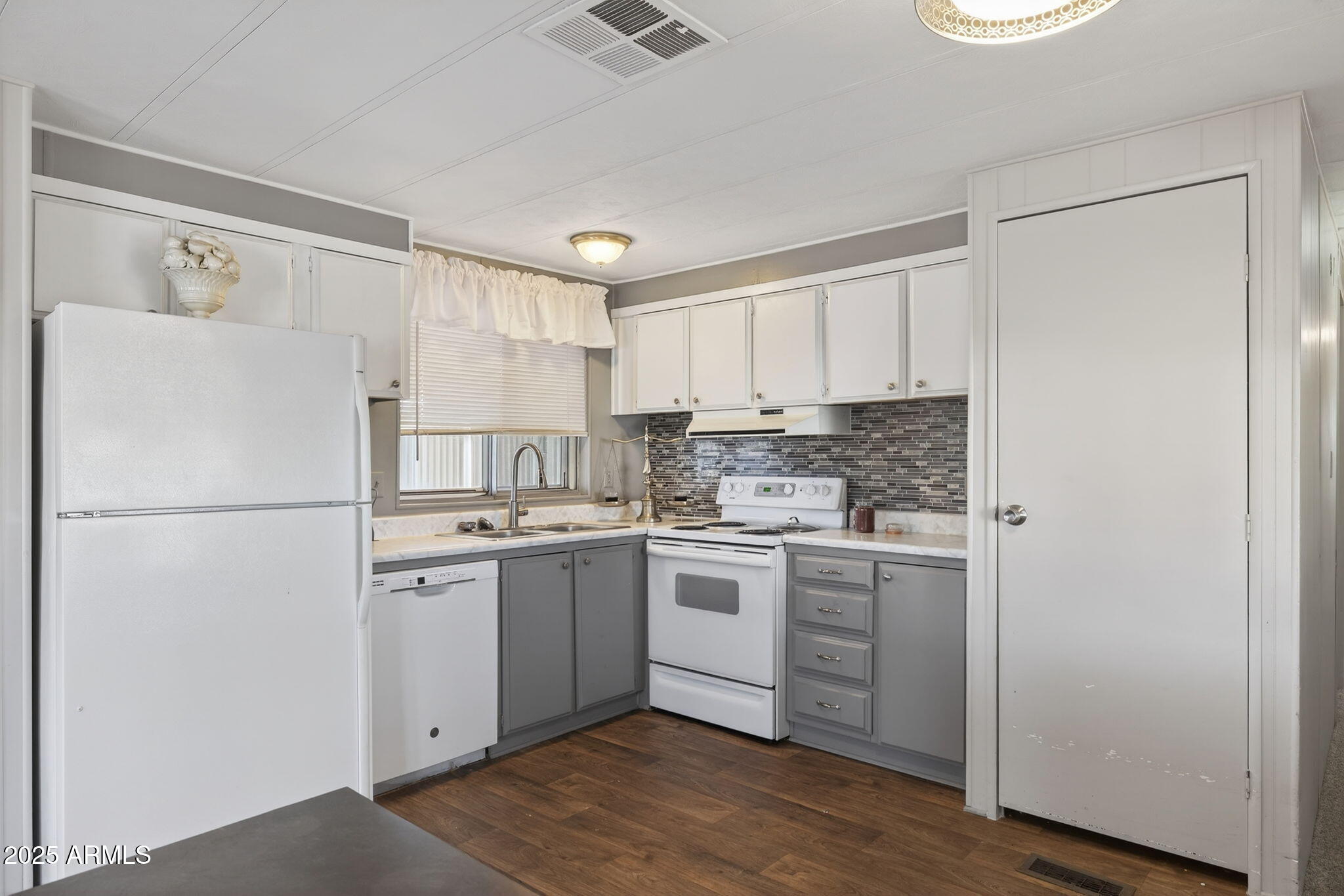 201 South Greenfield Road, Unit 310 Mesa, AZ 85206 - Photo 12 of 34 a kitchen with a white refrigerator freezer a sink and dishwasher with wooden floor
