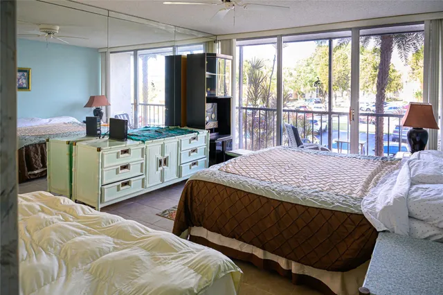 a bedroom with a bed and large windows