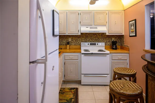 a kitchen with stainless steel appliances granite countertop a stove a refrigerator and a microwave
