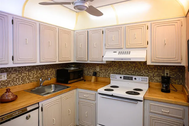 a kitchen with white cabinets and white appliances