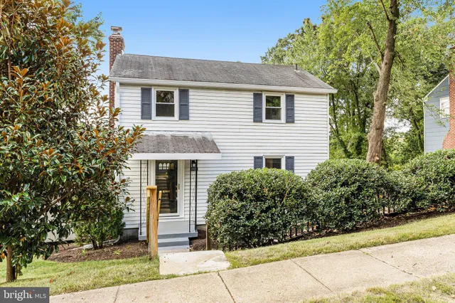 a front view of house with yard and trees around