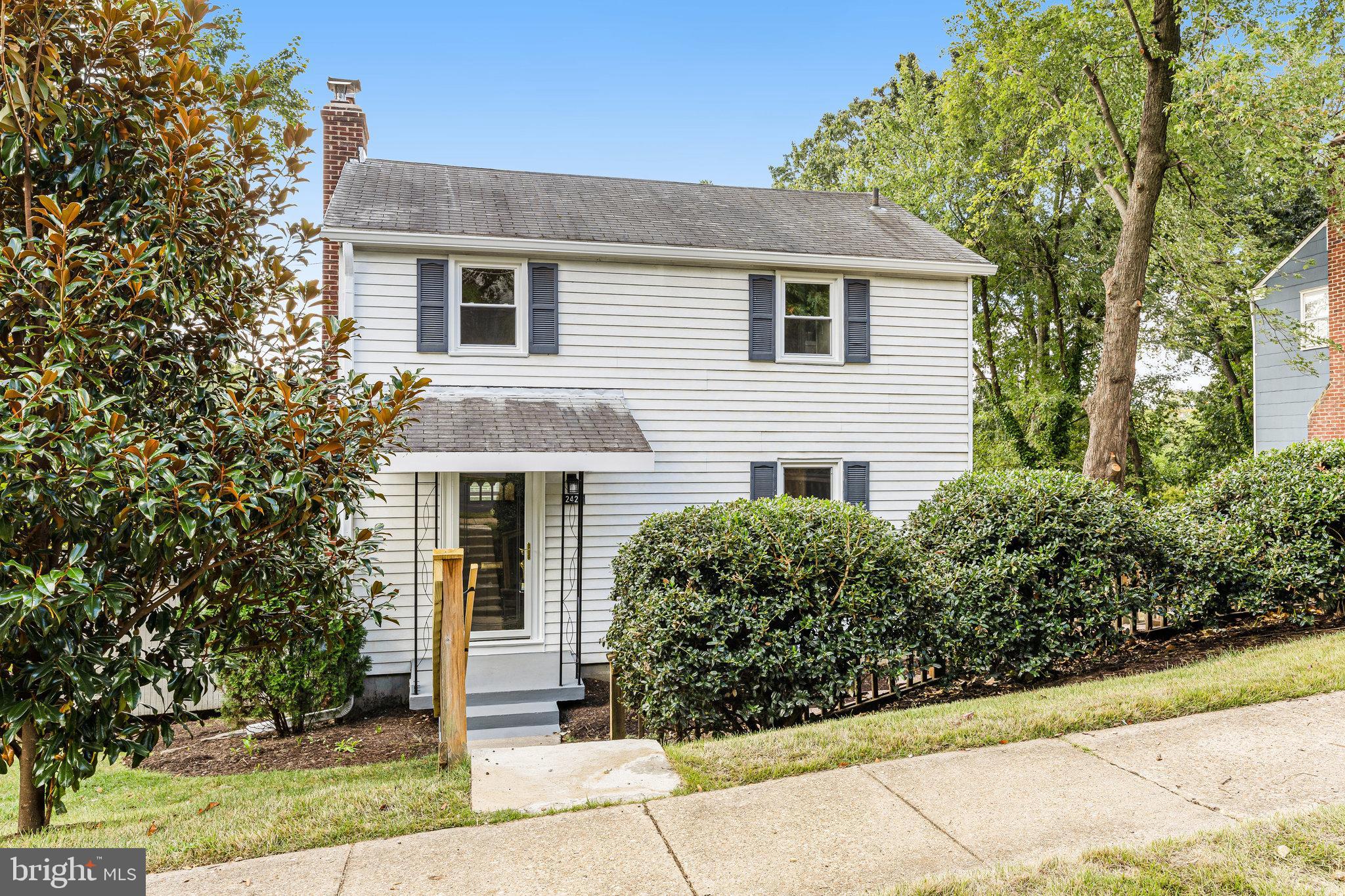 a front view of house with yard and trees around