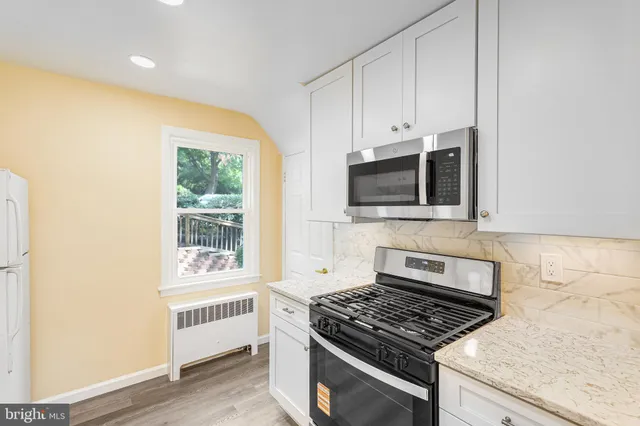 a kitchen with granite countertop a stove and a microwave