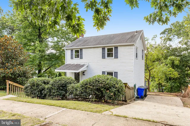 a view of a house with a yard and large tree