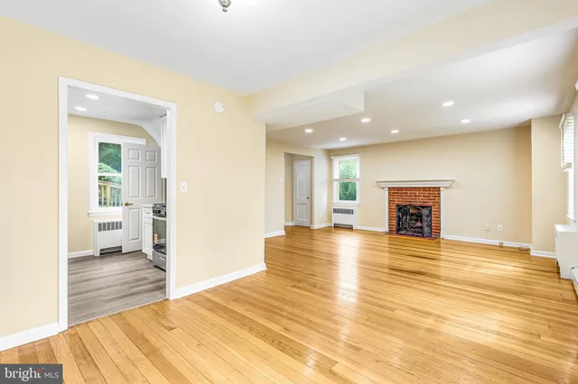 a view of a livingroom with wooden floor and a fireplace