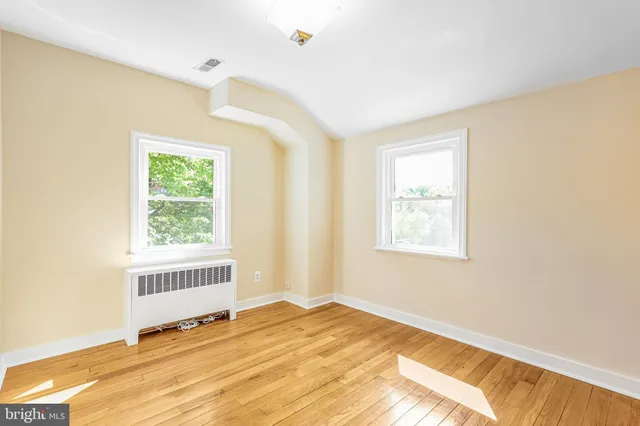 a view of a bedroom with wooden floor and a window