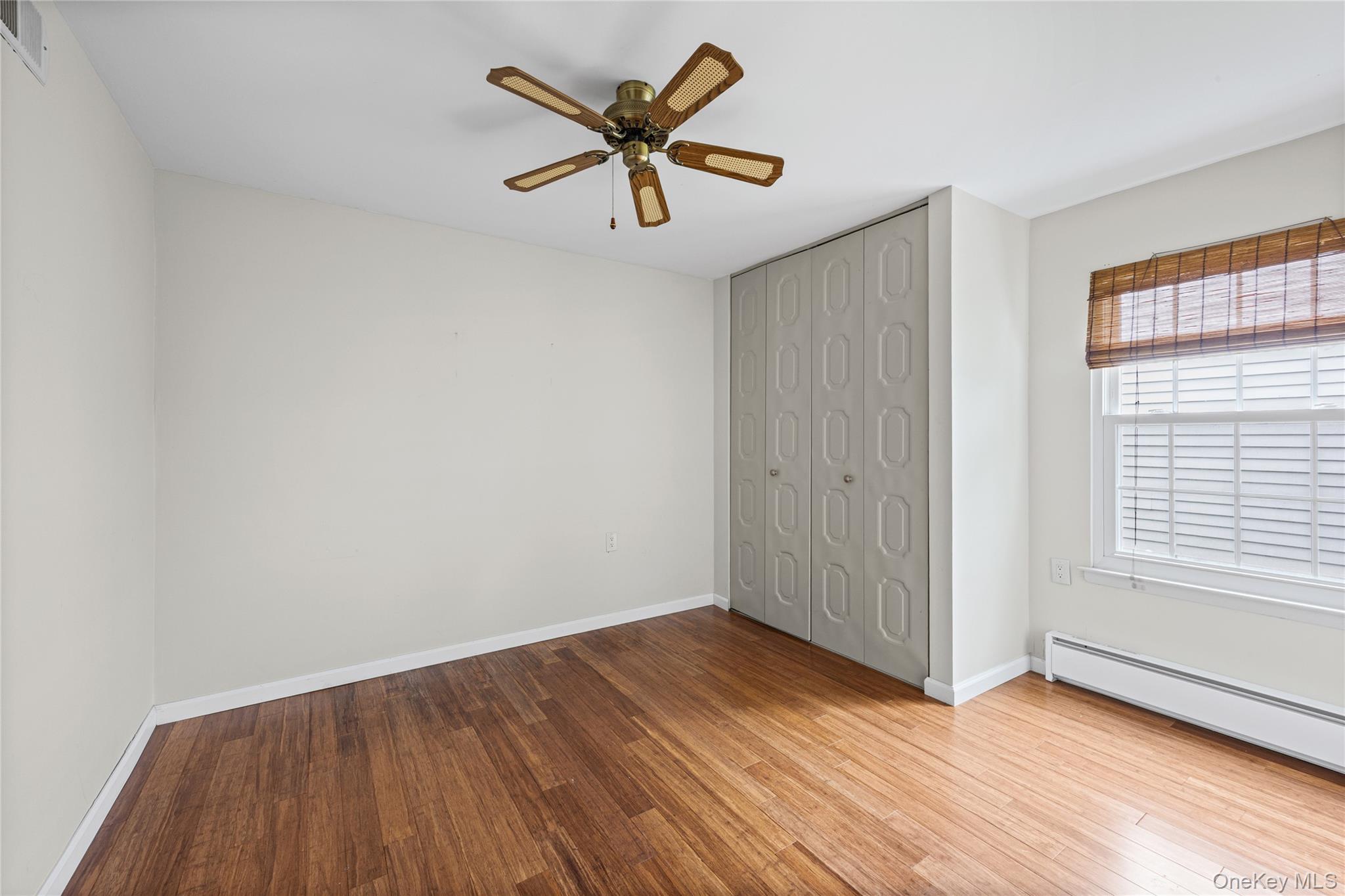 220 Belfast Lane Ridge, NY 11961 - Photo 39 of 44 an empty room with wooden floor and windows