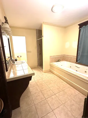 a bathroom with a sink mirror and a bathtub
