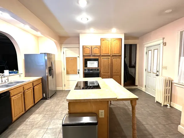 a kitchen with a refrigerator and a stove top oven