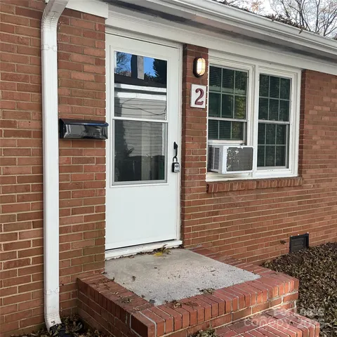 a view of a brick house with a door and wooden door