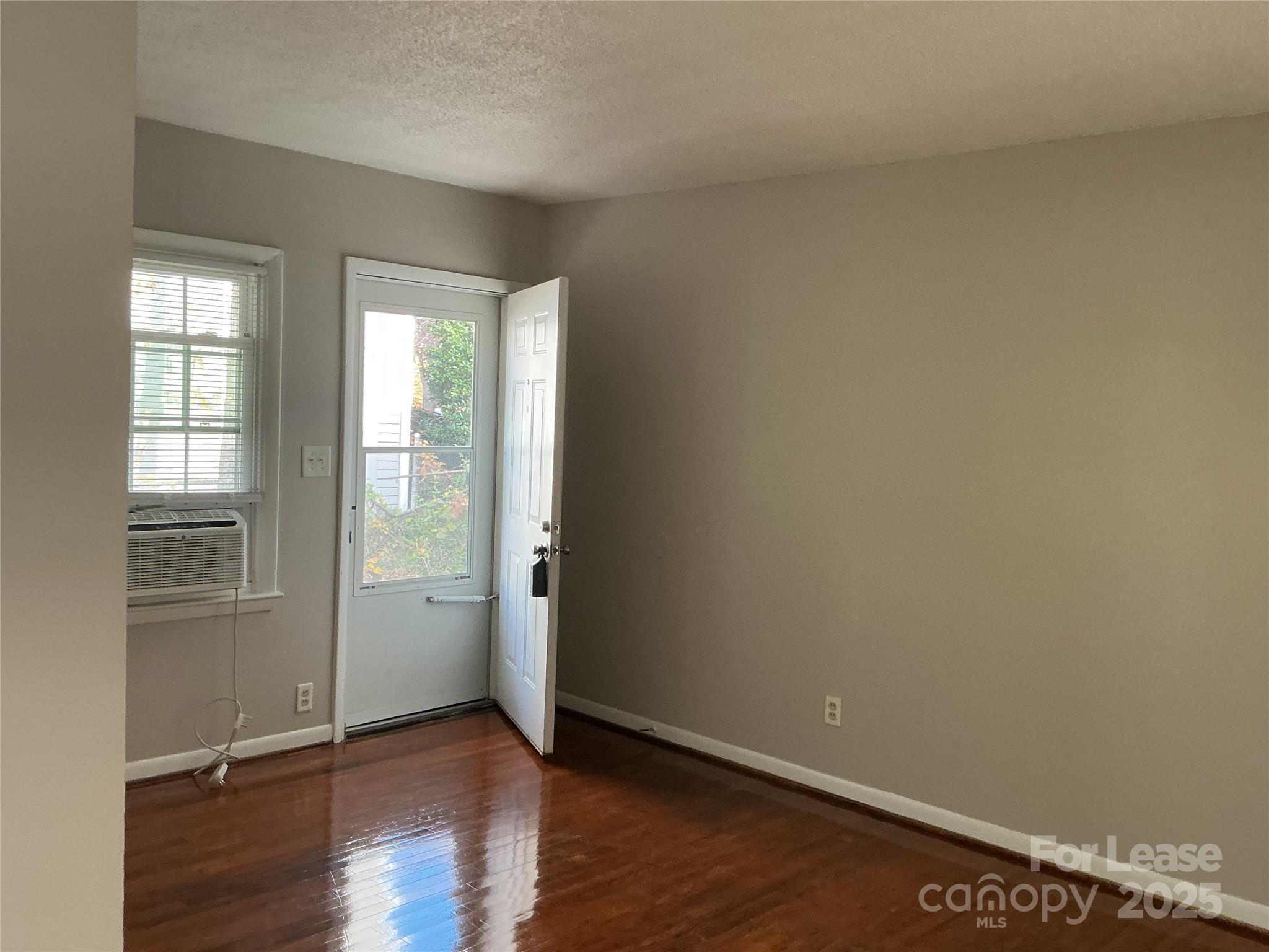 218 Grandin Road, Unit 2 Charlotte, NC 28208 - Photo 4 of 8 an empty room with wooden floor and windows