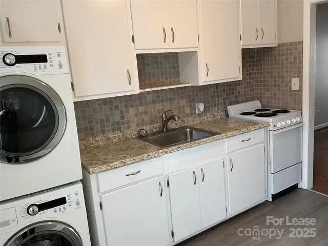 a kitchen with white cabinets and sink