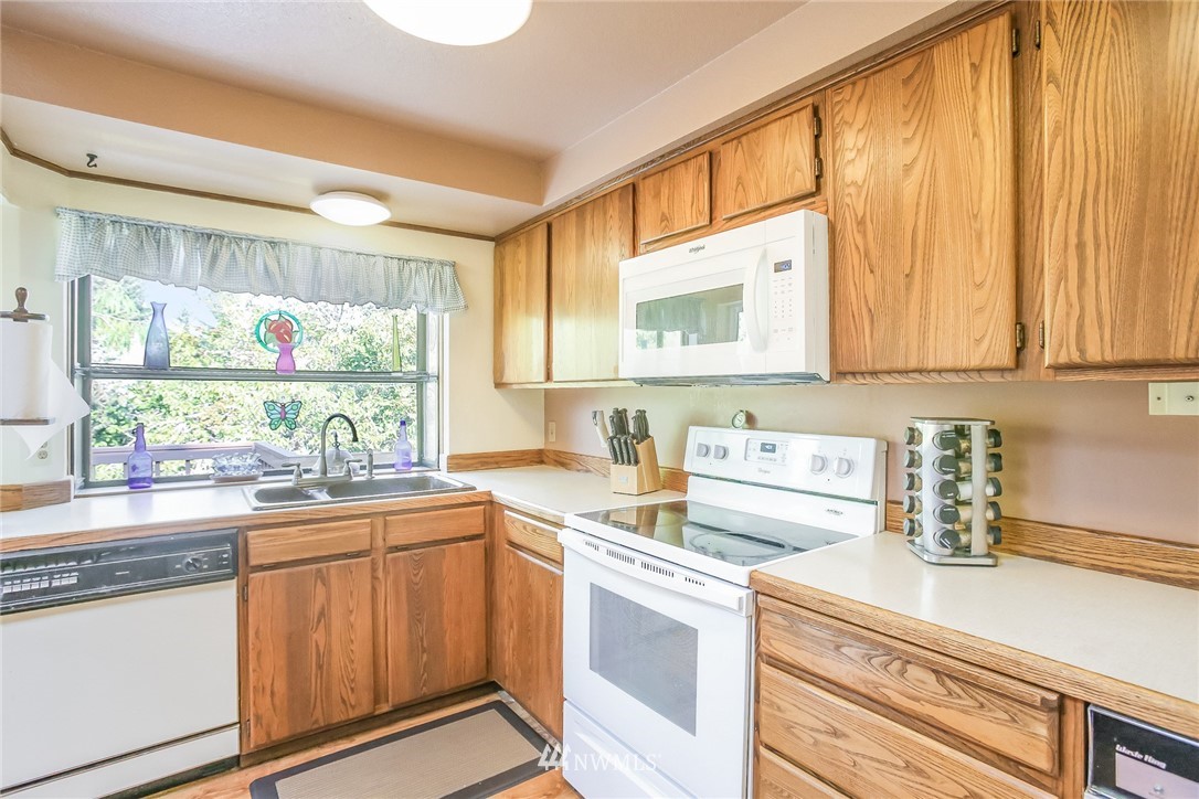 17848 156th Place Southeast Renton, WA 98058 - Photo 6 of 24 a kitchen with stainless steel appliances a sink a stove and cabinets