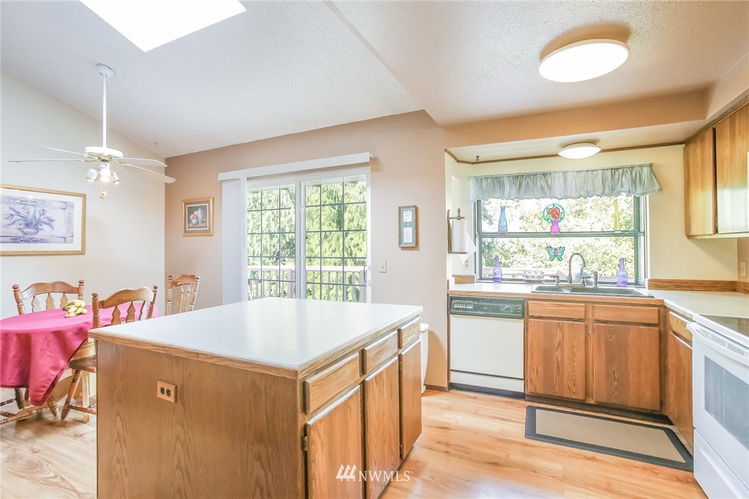 17848 156th Place Southeast Renton, WA 98058 - Photo 7 of 24 a dining hall with stainless steel appliances granite countertop a sink and dishwasher a stove with wooden floors