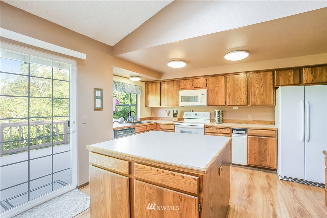 17848 156th Place Southeast Renton, WA 98058 - Photo 8 of 24 a kitchen with a refrigerator a stove a sink dishwasher with a dining table and chairs