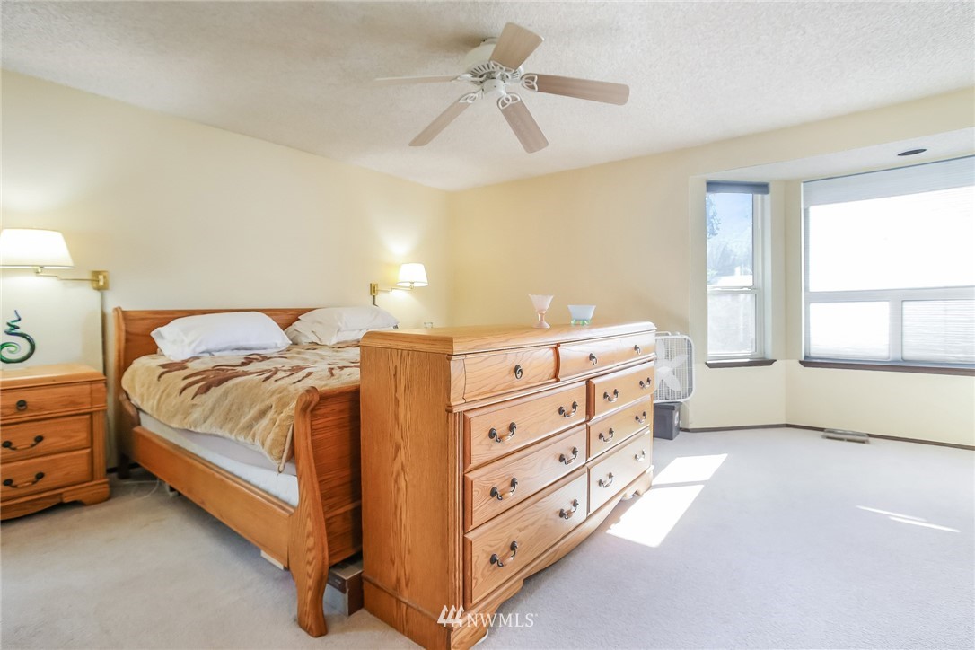 17848 156th Place Southeast Renton, WA 98058 - Photo 10 of 24 a spacious bedroom with a bed and a chandelier