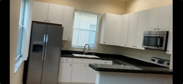 a kitchen with granite countertop a refrigerator and a sink